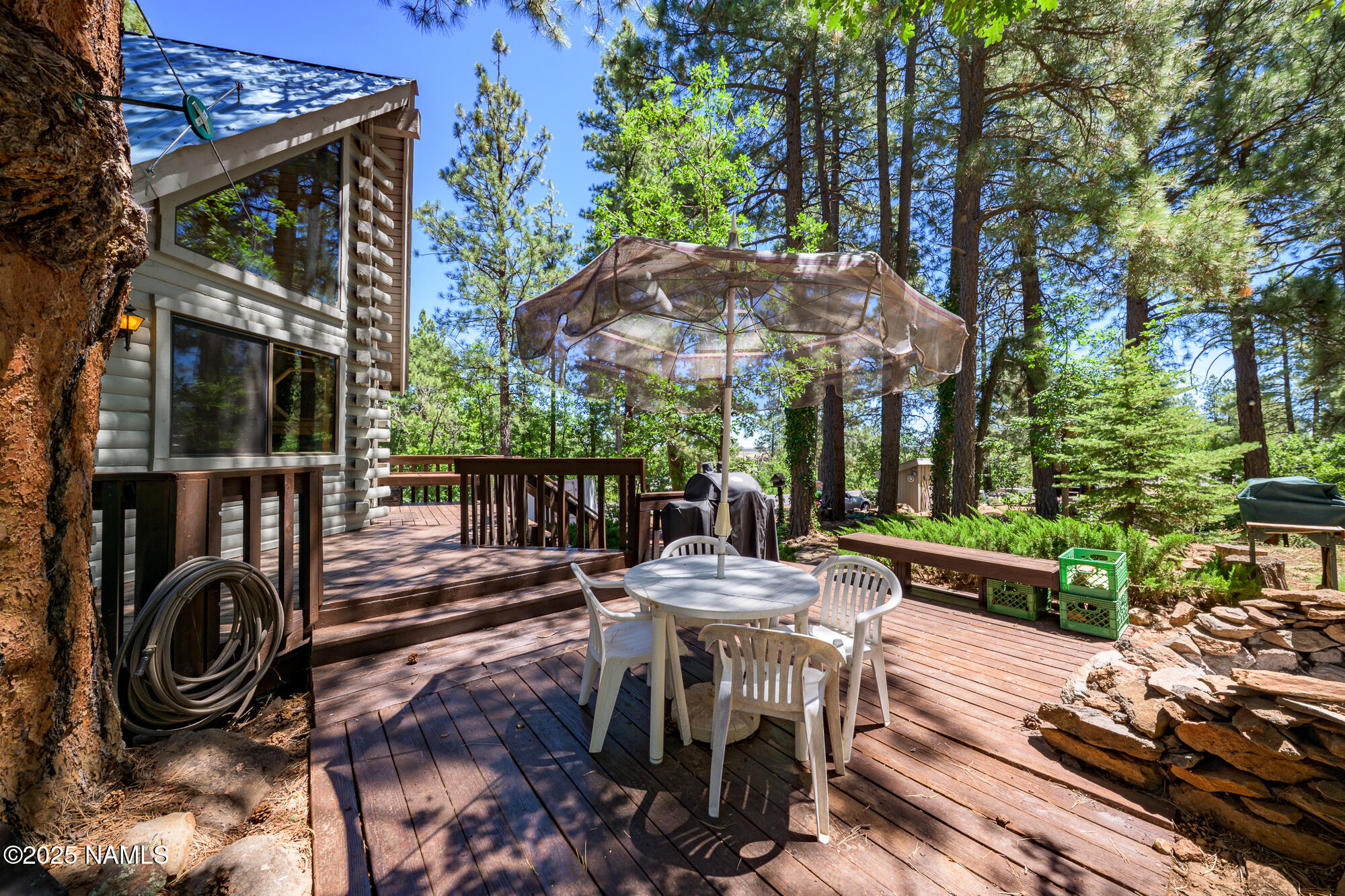 4680 Mormon Lake Road Mormon Lake, AZ 86038 - Photo 24 of 34 a view of a patio with table and chairs potted plants with wooden floor and fence