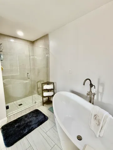 a bathroom with a tub a sink and a shower