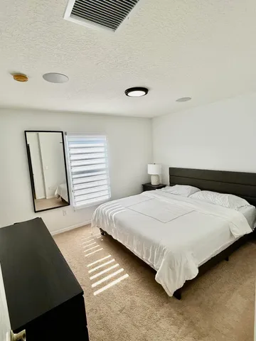 a bedroom with a bed and a night stand