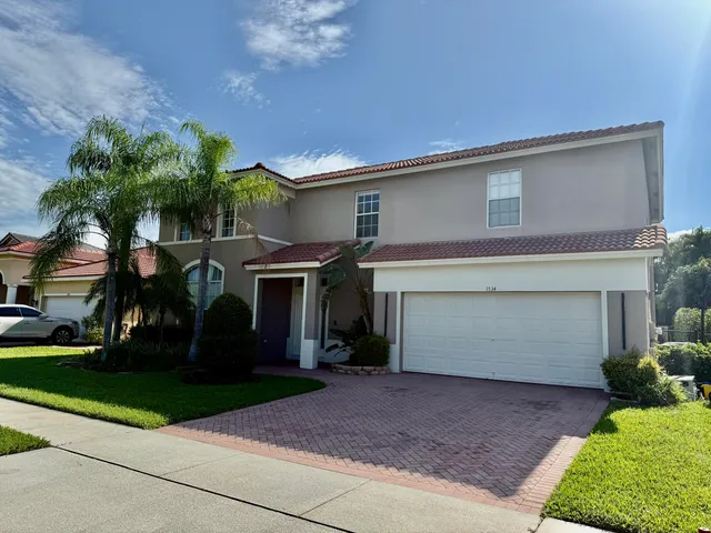 a front view of a house with a yard and a garage