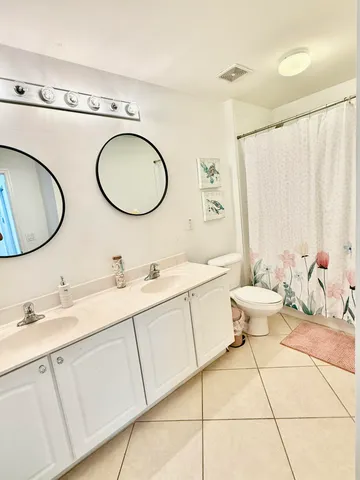 a bathroom with a granite countertop sink mirror vanity and toilet