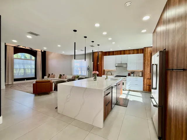 a large kitchen with stainless steel appliances a large counter top