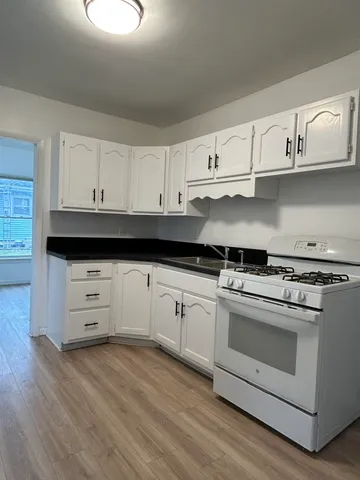a kitchen with white cabinets and appliances