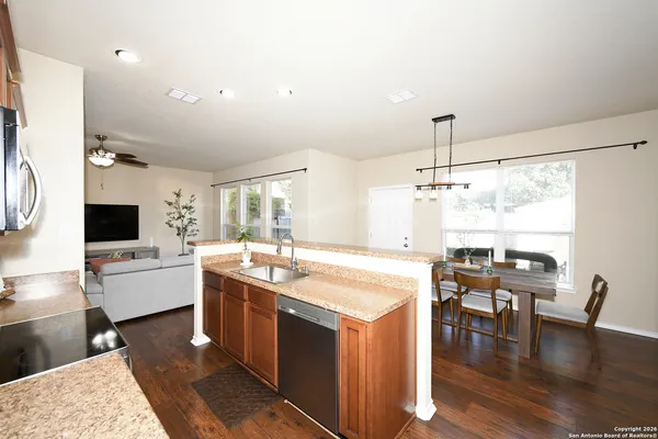 a kitchen with a stove a counter space dining table and chairs
