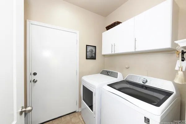 a view of washer and dryer with kitchen in the background