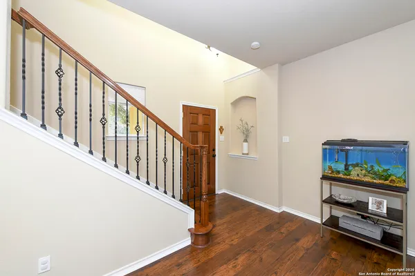 a view of a hallway with wooden floor and staircase