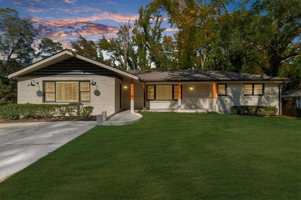 a front view of a house with a garden and yard
