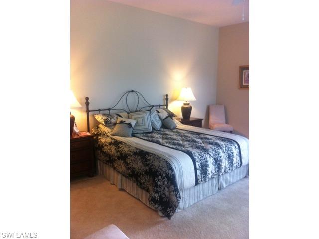 8248 Quaker Place Naples, FL 34104 - Photo 11 of 14 a bedroom with a bed and a lamp