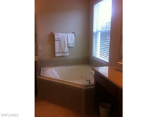 8248 Quaker Place Naples, FL 34104 - Photo 12 of 14 a bathroom with a bathtub and a window