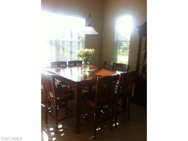 8248 Quaker Place Naples, FL 34104 - Photo 6 of 14 a dining room with a table and chairs