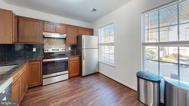 a kitchen with stainless steel appliances a refrigerator sink and cabinets