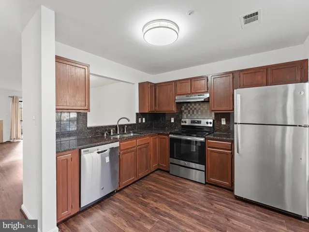 a kitchen with stainless steel appliances granite countertop a refrigerator stove and sink