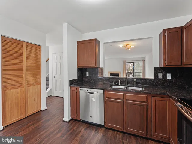 a kitchen with stainless steel appliances granite countertop wooden cabinets and a refrigerator