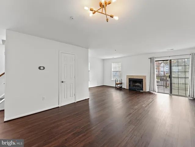 a view of empty room with wooden floor and fireplace