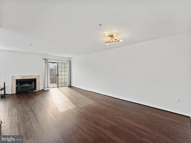 an empty room with wooden floor and fire place