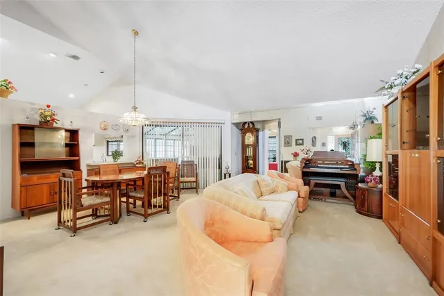 a living room with furniture a flat screen tv and kitchen view