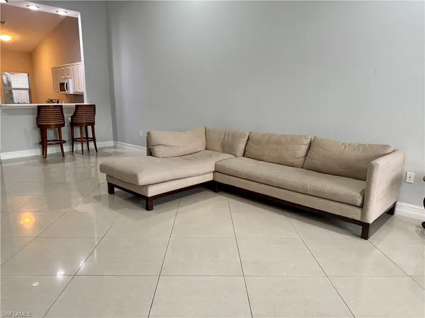 a living room with furniture and a dining table with a potted plant