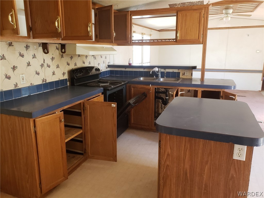 14185 Powerline Road Kingman, AZ 86401 - Photo 11 of 22 a kitchen with stainless steel appliances granite countertop a sink stove and cabinets