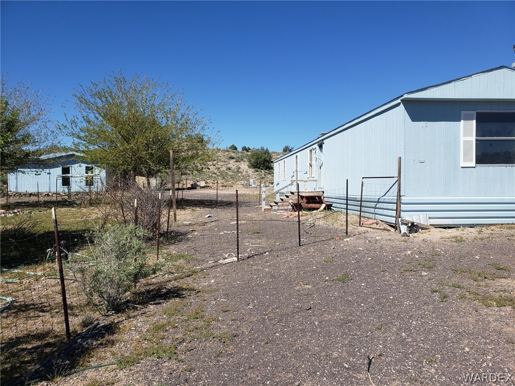 14185 Powerline Road Kingman, AZ 86401 - Photo 21 of 22 a view of a house with backyard and trees