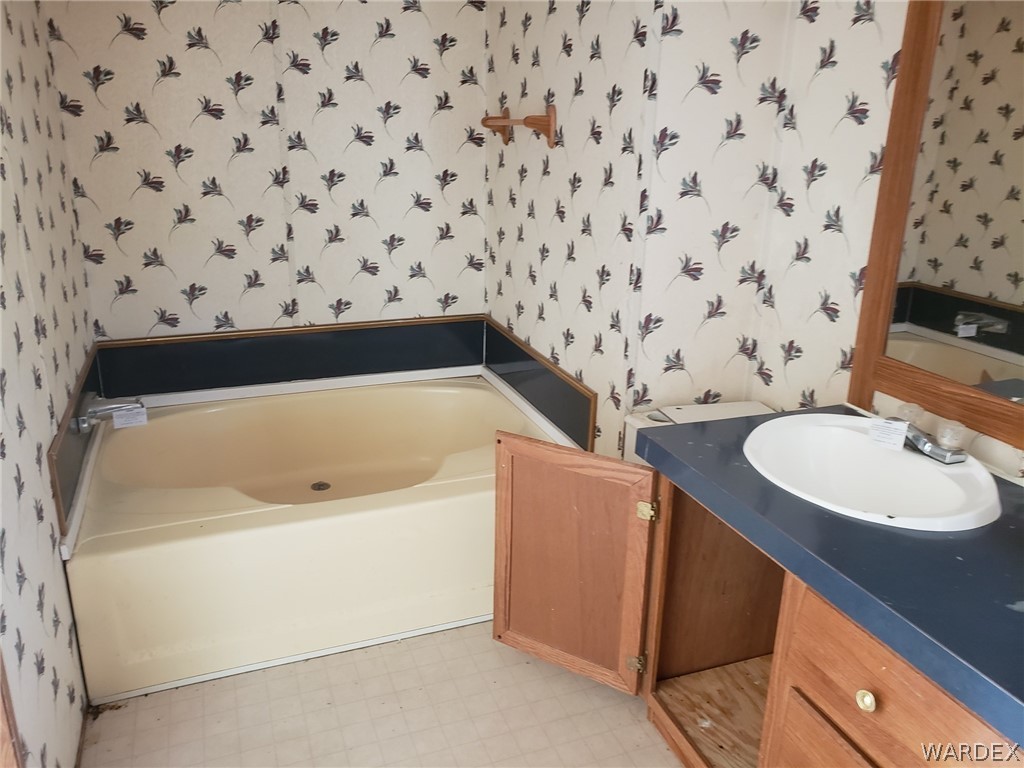 14185 Powerline Road Kingman, AZ 86401 - Photo 8 of 22 a bathroom with a sink a toilet and a bathtub