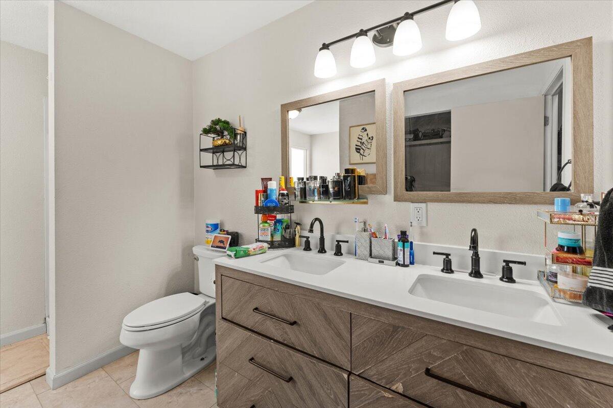 10755 Cody Drive Red Bluff, CA 96080 - Photo 21 of 77 a bathroom with a toilet a sink a mirror and vanity