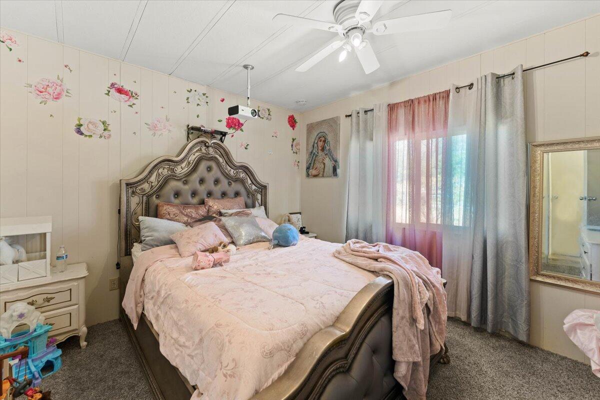 10755 Cody Drive Red Bluff, CA 96080 - Photo 25 of 77 a bedroom with a bed and a chandelier