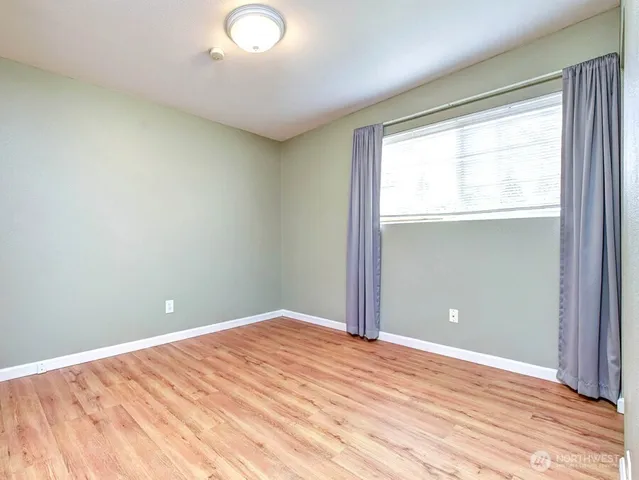 a view of empty room with wooden floor