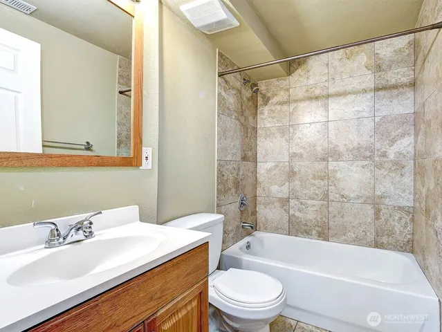 a bathroom with a sink mirror toilet and bathtub