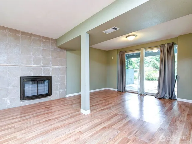 a view of a room with wooden floor and fireplace