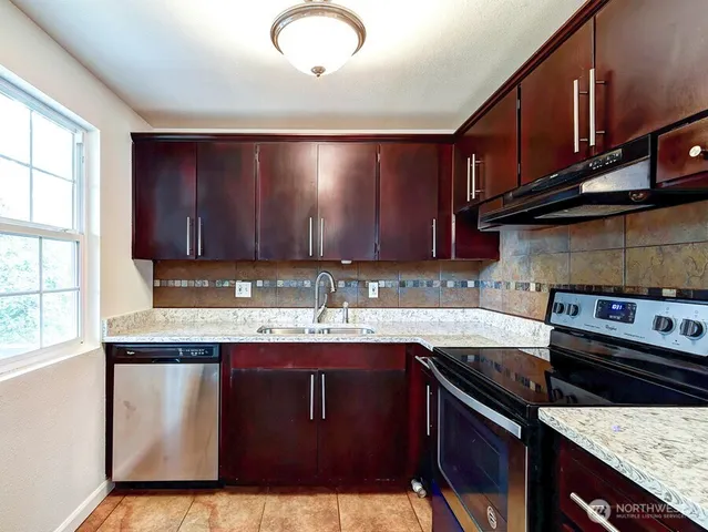 a kitchen with a sink stove top oven and cabinets
