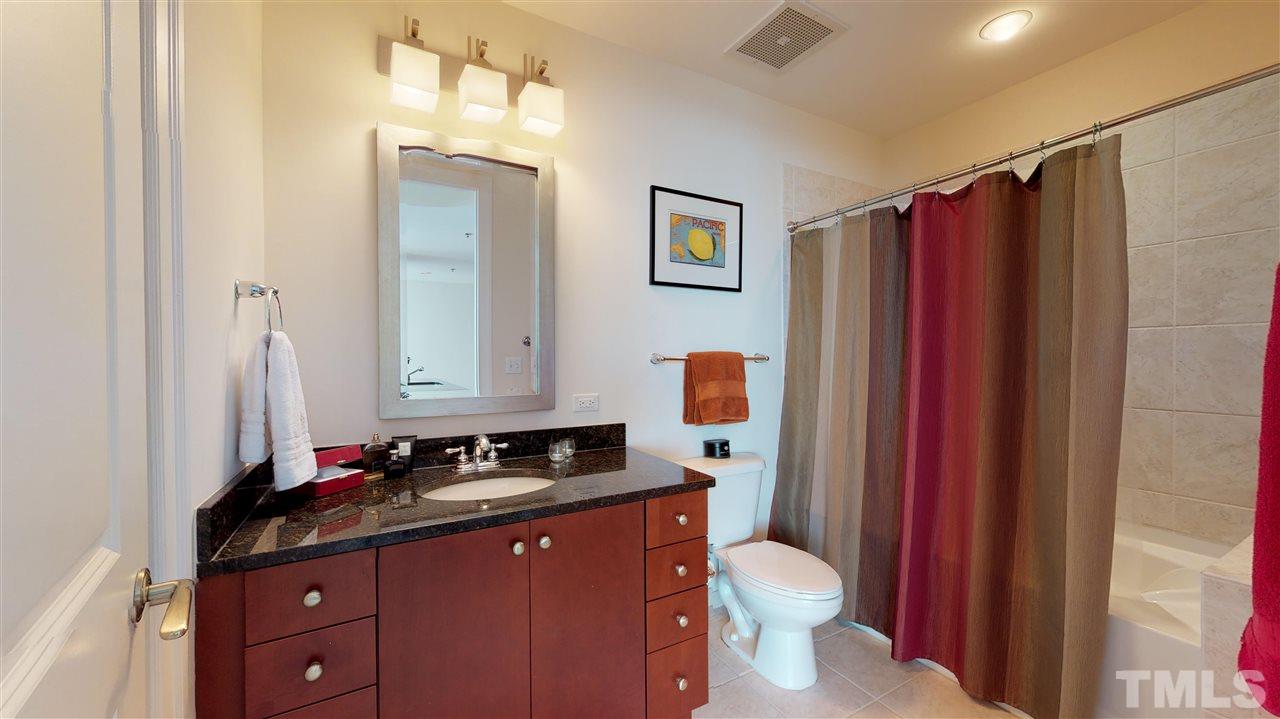 301 Fayetteville Street, Unit 2408 Raleigh, NC 27601 - Photo 12 of 19 Large bathroom with shower/tub and a well-lit vanity.