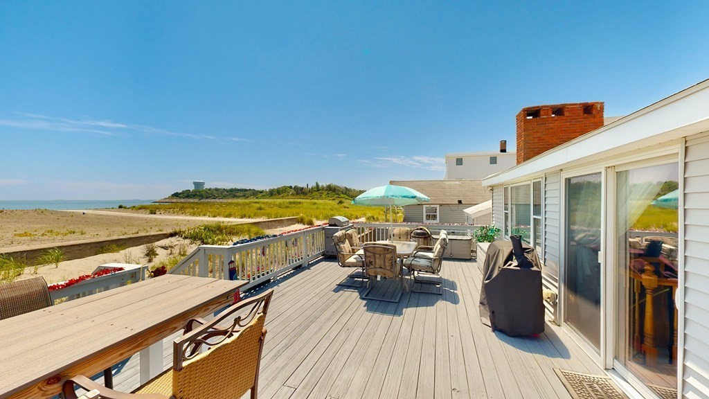 a view of a balcony with chairs and wooden floor