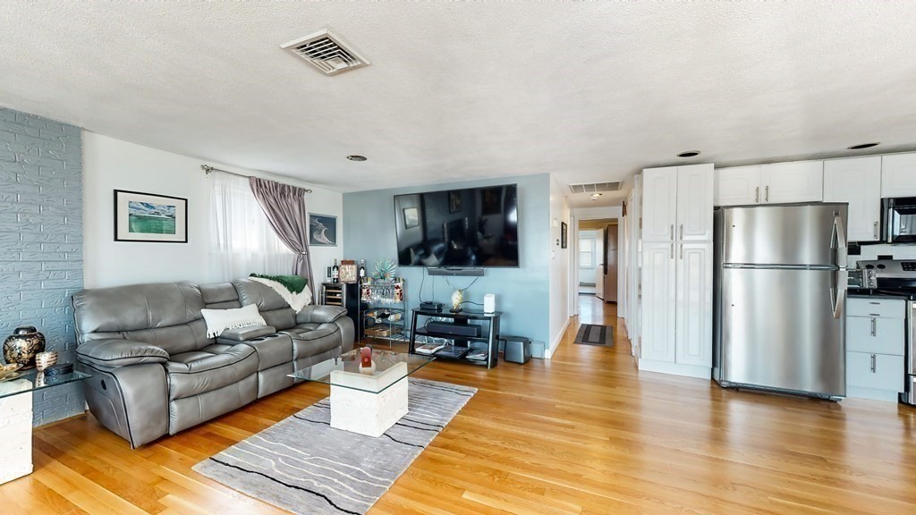 151 The Strand Winthrop, MA 02152 - Photo 11 of 36 a living room with furniture wooden floor and a flat screen tv