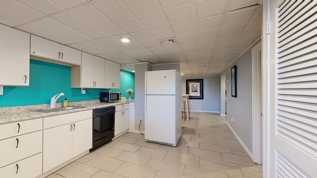 151 The Strand Winthrop, MA 02152 - Photo 18 of 36 a kitchen with granite countertop a refrigerator and a sink