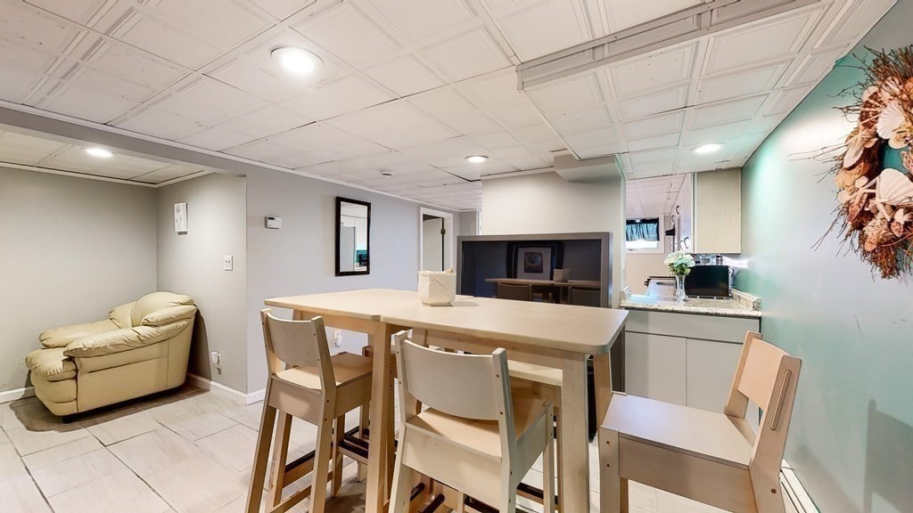 151 The Strand Winthrop, MA 02152 - Photo 21 of 36 a kitchen with a table chairs microwave and cabinets