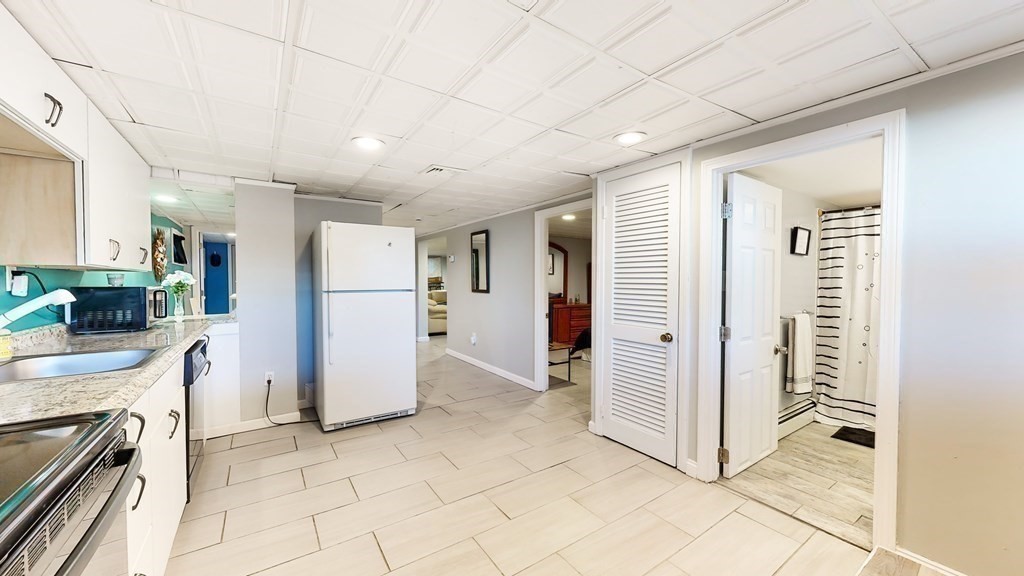 151 The Strand Winthrop, MA 02152 - Photo 23 of 36 a view of a kitchen with a refrigerator and a stove top oven