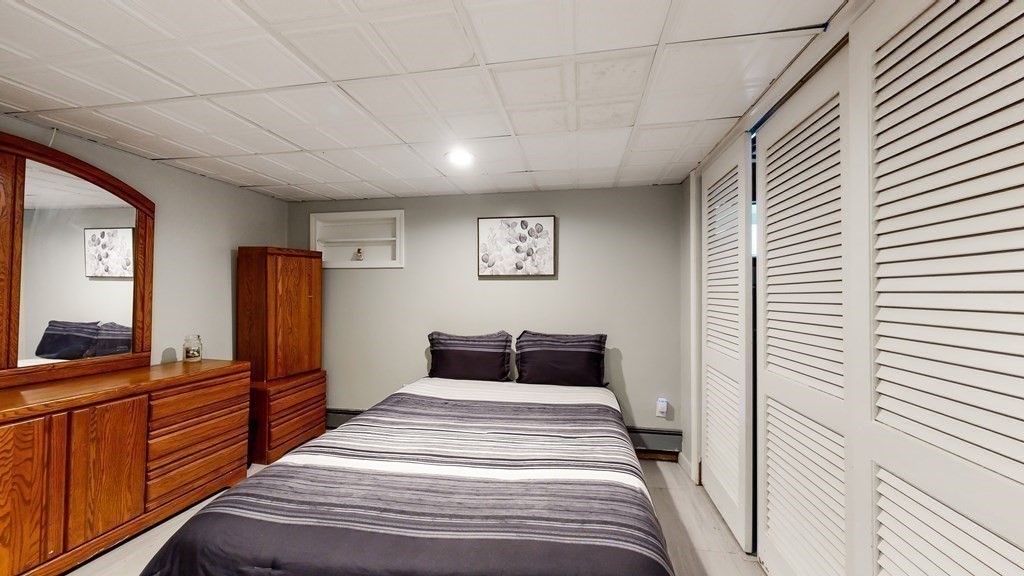 151 The Strand Winthrop, MA 02152 - Photo 27 of 36 a bedroom with a bed and wooden floor