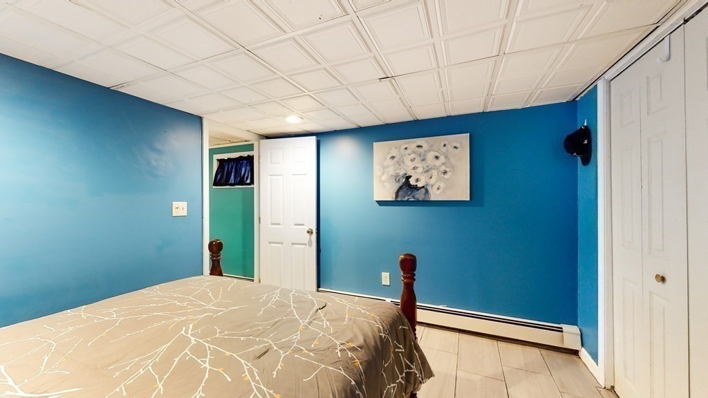 151 The Strand Winthrop, MA 02152 - Photo 30 of 36 a bedroom with a bed and a chandelier