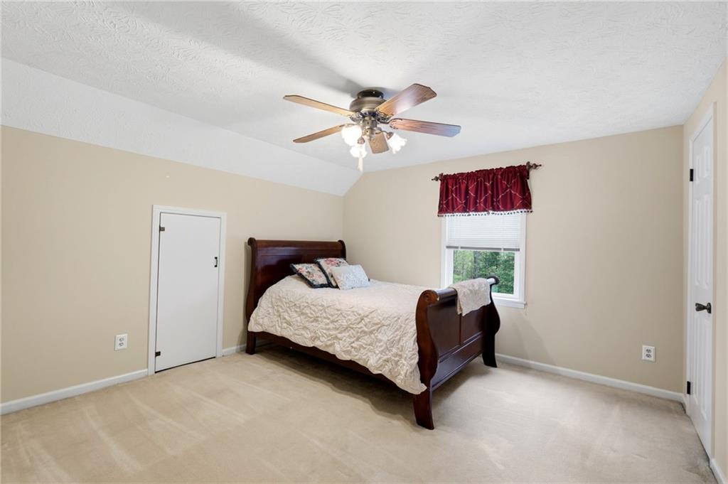 3121 Bonds Lake Road Northwest Conyers, GA 30012 - Photo 22 of 36 a bedroom with a bed and a chandelier
