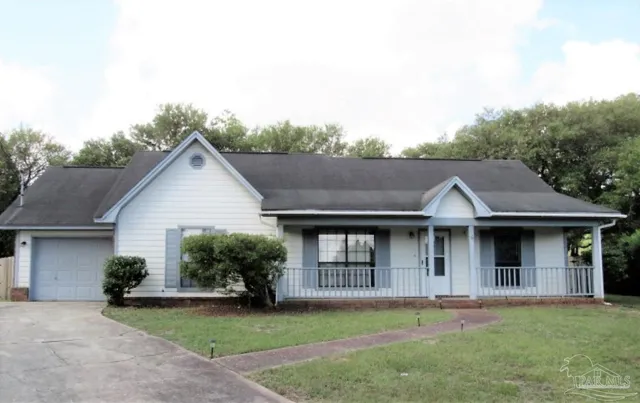 a front view of a house with a garden and yard