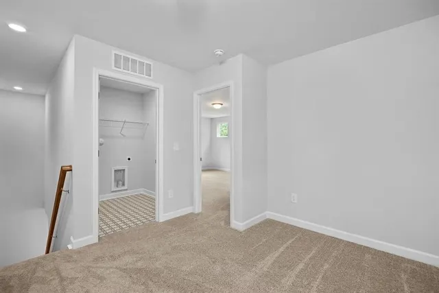 an empty room with wooden floor and a bathroom