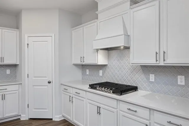 a kitchen with white cabinets and appliances