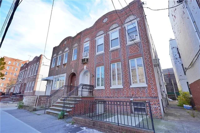 a view of a brick building next to a yard