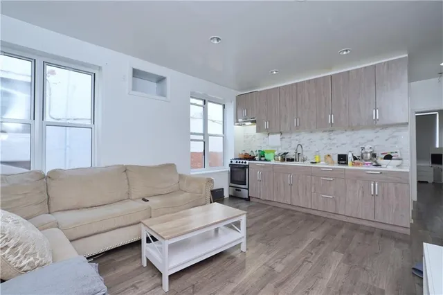a living room with furniture and kitchen view