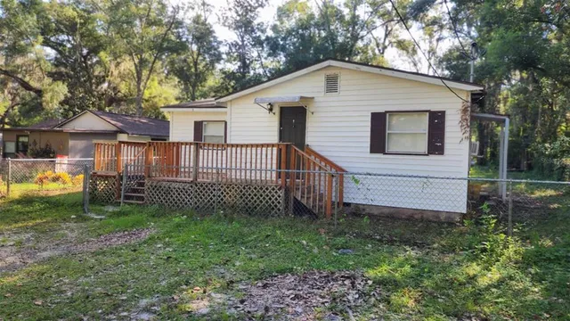 a front view of a house with a yard and fence