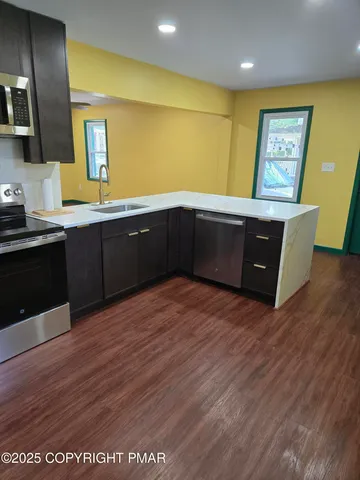 a kitchen with stainless steel appliances double vanity sink and a refrigerator