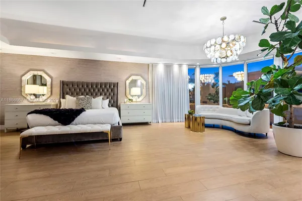 a bedroom with a large bed couch and a balcony view