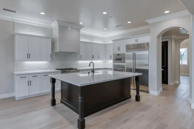 a kitchen with a stove a sink a refrigerator and cabinets
