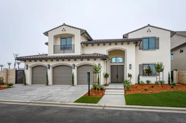a view of a white house with a outdoor space and plants