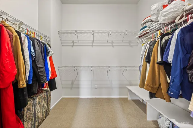 a view of walk in closet with clothes and shoes